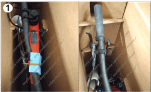 bicycle handlebars and frame secured inside a cardboard box with padding