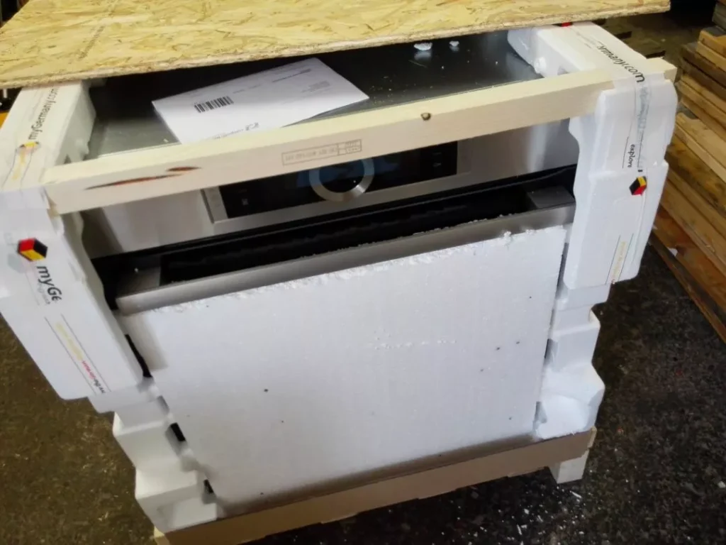household appliance partially crated with foam and wooden frame protection