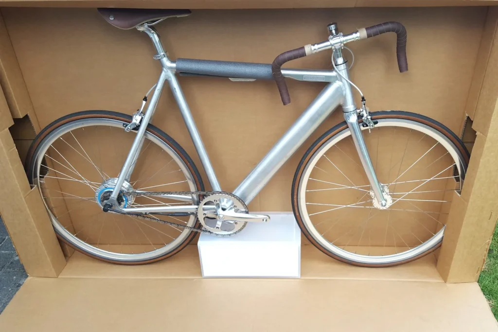 silver bicycle packed neatly inside large protective cardboard box
