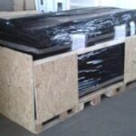 wooden crate on pallet wrapped with black plastic for shipping